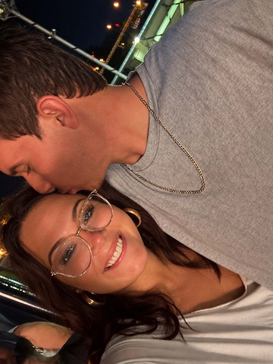 Josh kissing Whitney on the forehead as she smiles at the camera.
